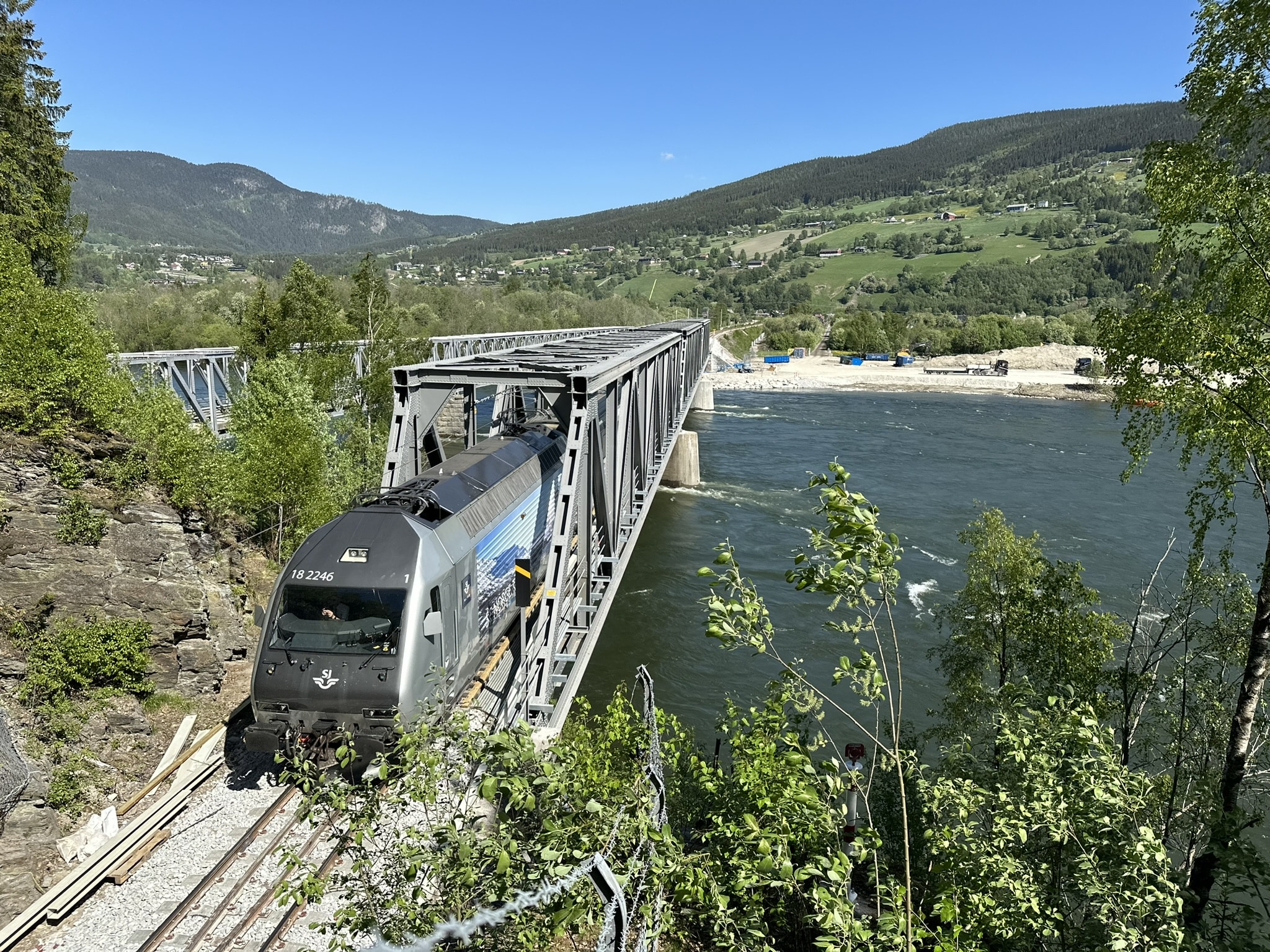 Et av de første persontogene passerer her Randklev bru etter gjenåpningen 21.mai 2024.