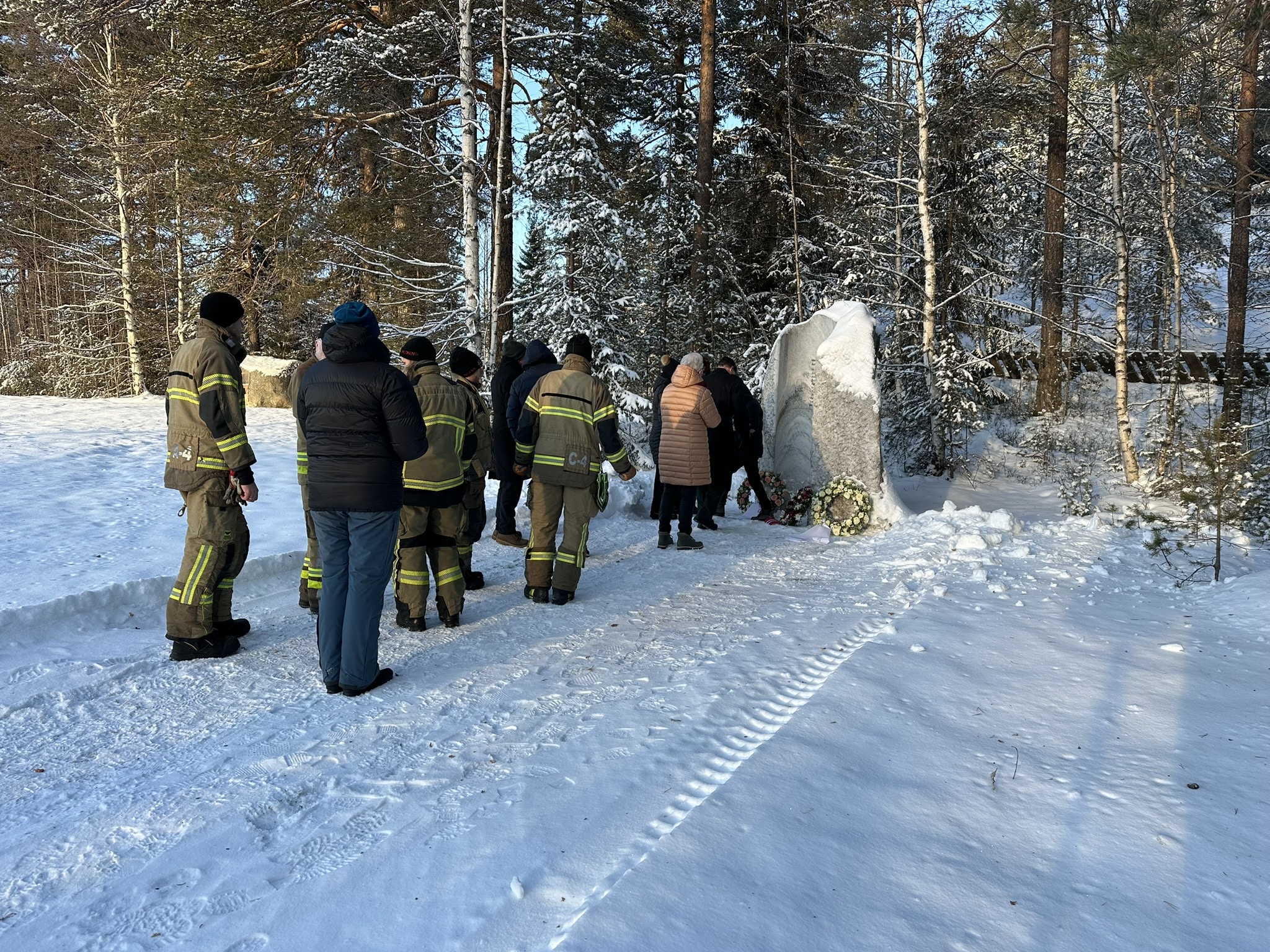 Minnemarking Åsta-ulykken. Folk fra redningsetatene og pårørerende tenner lys ved minnesteinen.